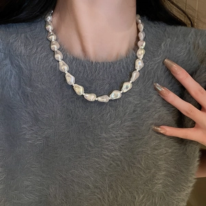 Close-up of model wearing an irregular pearl geometric necklace in minimalist fashion