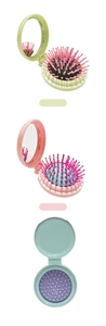 Close-up of compact foldable hairbrush with built-in mirror in various pastel colors