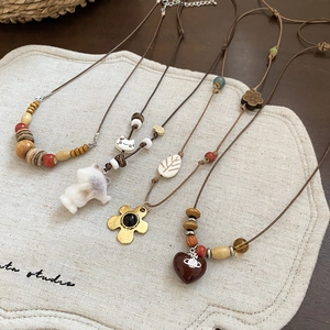 Colliers ethniques en perles de bois avec pendentifs en céramique et détail de cœur