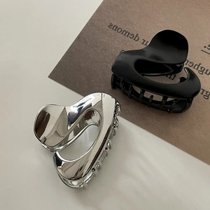 Detail of heart-shaped hair claw clips in polished silver and matte black finish