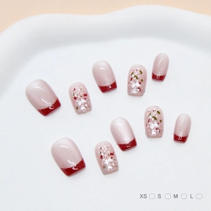 Dettaglio di unghie finte French cat-eye con paillettes rosse e finitura perlata lucida