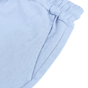 Close-up of light blue linen shorts featuring elastic waistband and side pocket detail