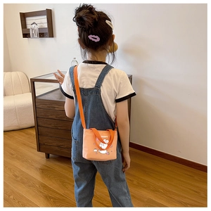 Cute pink rabbit canvas crossbody bag for kids with orange strap worn by girl