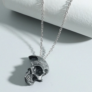 Gothic half-face skull necklace in vintage silver finish on a display stand