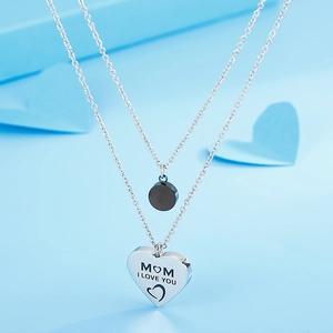 Dettaglio della collana a doppio strato con ciondolo a cuore inciso MOM e I LOVE YOU