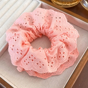 Close-up of pink cotton embroidery hair scrunchie with hollow lace edges on a tray