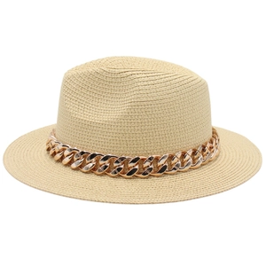 Détail du chapeau de paille beige tissé avec une bande de chaîne dorée élégante