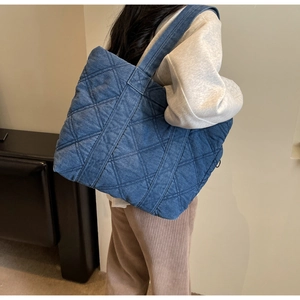 Détail du sac fourre-tout en denim bleu matelassé avec motif en losange et grande capacité