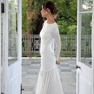 Detail des weißen langärmeligen Plissee-Kleides mit elegantem Chiffonsaum und seitlicher Raffung