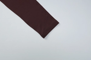 Detailed close-up showing the precise stitching on the sleeve of a dark brown French top