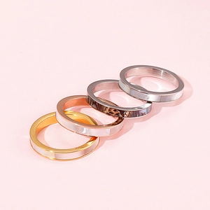 Macro detail of multi-layered Roman numeral rings with shell inlays in gold and silver