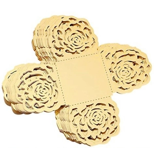 Macro view of champagne gold laser-cut hollow rose patterns on paper favor boxes
