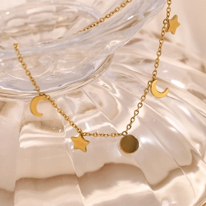 Macro shot of gold plated stainless steel bracelet with star moon and round charms