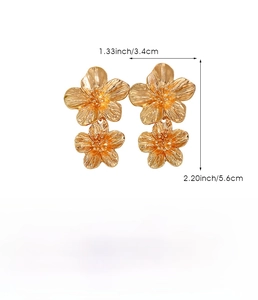 Detailed view of large gold floral earrings in zinc alloy with brushed metal finish texture
