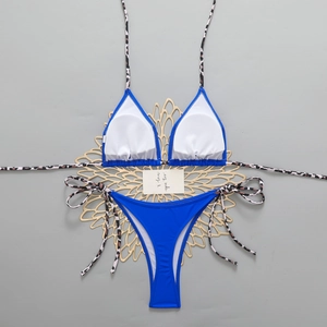 Detail of royal blue bikini with leopard print ties on a decorative golden mat