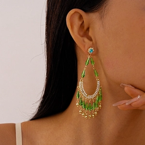 Close-up of long emerald green tassel earrings with sea blue rhinestones on a model