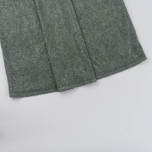Detail of dark green shimmering fabric showing fine knit texture and double-stitched hemline