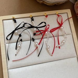 Detail of elegant bow and pearl tassel earrings on a beige velvet jewelry display tray