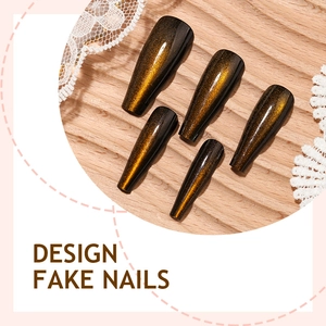 Long coffin fake nails with golden amber cat eye effect on dark base with lace detail