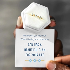 Detailed close-up of three blue flower rings with motivational gift card and velvet box