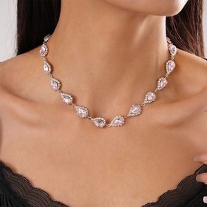 Macro detail of a 2-piece silver necklace with pink teardrop crystal and halo rhinestones
