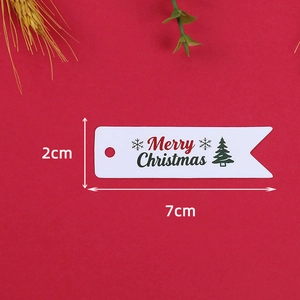 Dettaglio delle etichette natalizie 2x7cm con motivo ad albero su sfondo rosso