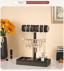 Three-tier jewelry stand detail showing gold arrow bar and geometric base for storage