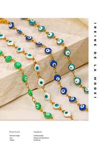 Detail of colorful enamel evil eye charms on a golden stainless steel chain bracelet