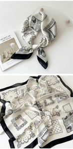 Detail of silk-like paisley square scarf with black and white patterns and smooth texture