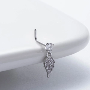 Macro view of silver L-shaped nose stud with round zircon and dangling teardrop pendant