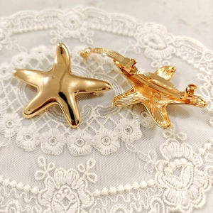 Detailed view of golden starfish hair accessory with smooth and textured metal finishes