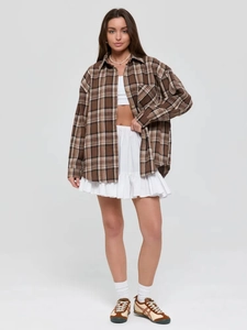 Close-up of brown plaid long sleeve shirt featuring a front pocket and buttoned collar