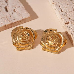 Vue macro détaillée de boucles d'oreilles rose dorée métallisée avec texture vintage