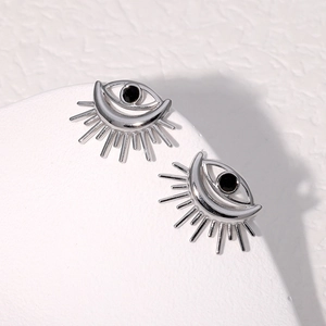 Macro shot of silver evil eye stud earrings with black center and radiant eyelashes detail