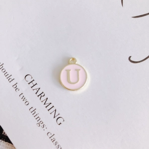 Detail of a pink enamel gold letter U charm pendant for DIY necklace and jewelry making