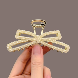 Elegant gold metal hair claw clip featuring a pearl-studded butterfly knot design