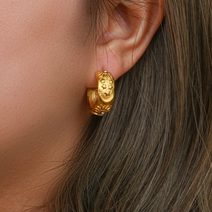Macro shot of 18K gold plated C-shape earring with celestial star and moon relief designs
