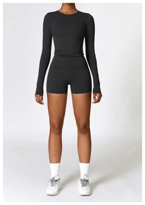 Ensemble de yoga noir moulant comprenant un haut à manches longues et un short de sport
