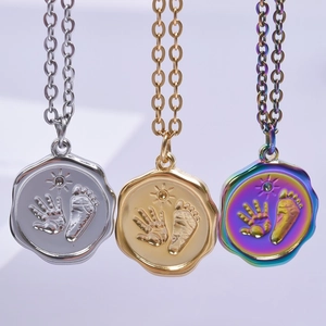 Three geometric stainless steel pendants with handprint and footprint engravings on chains