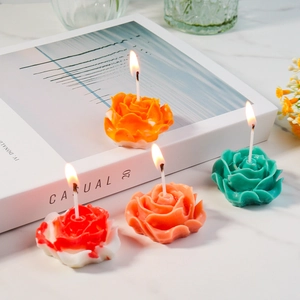Dettaglio di candele profumate a forma di rosa con trame di petali su marmo elegante