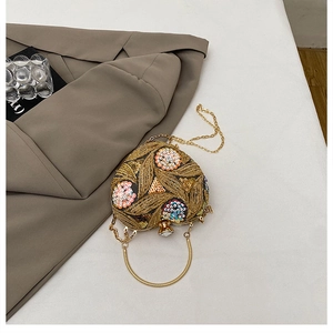 Detail of heart-shaped evening clutch with floral sequins and golden embroidery