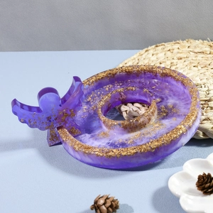 Macro detail of a purple resin angel decorative tray with embedded gold foil flakes