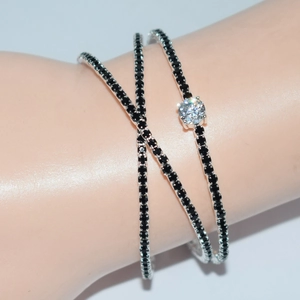 Detailed view of luxury silver cross bracelet with black stones and round clear center gem