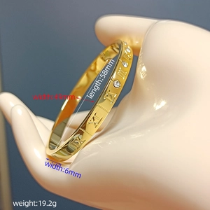 Gold Roman numeral bangle with crystals on a model, inner diameter 58mm by 49mm