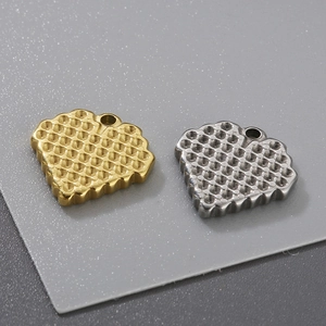 Macro shot of waffle-shaped metal charms in gold and silver finish with hanging holes