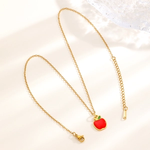 Detail of gold cherry pendant with red enamel and stainless steel cable chain clasp
