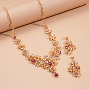 Detail of rose red crystal flower pendant and earrings in luxury gold settings