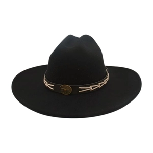 Close-up of a vintage bronze bull logo and white stitching on a black felt fedora band