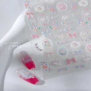 Close-up of 3D embossed nail stickers with cute bow and rabbit motifs on gradient nails