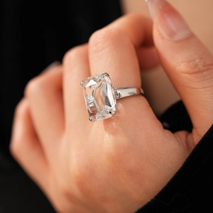 Macro detail of a 14k gold plated square zircon ring on a model's hand with luxury lighting